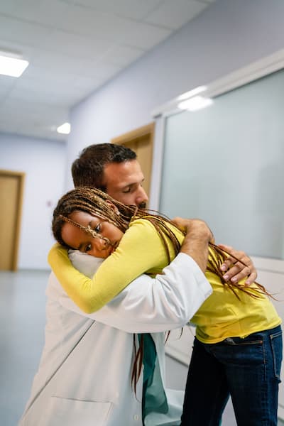 A doctor hugging a kid in the hospital's corridor