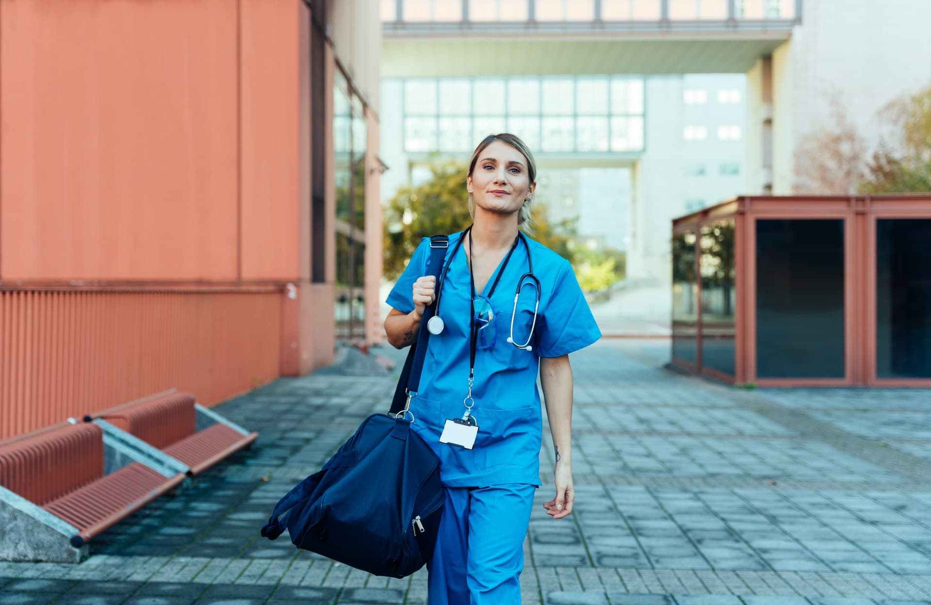 A young smiling female nurse outside a hospital