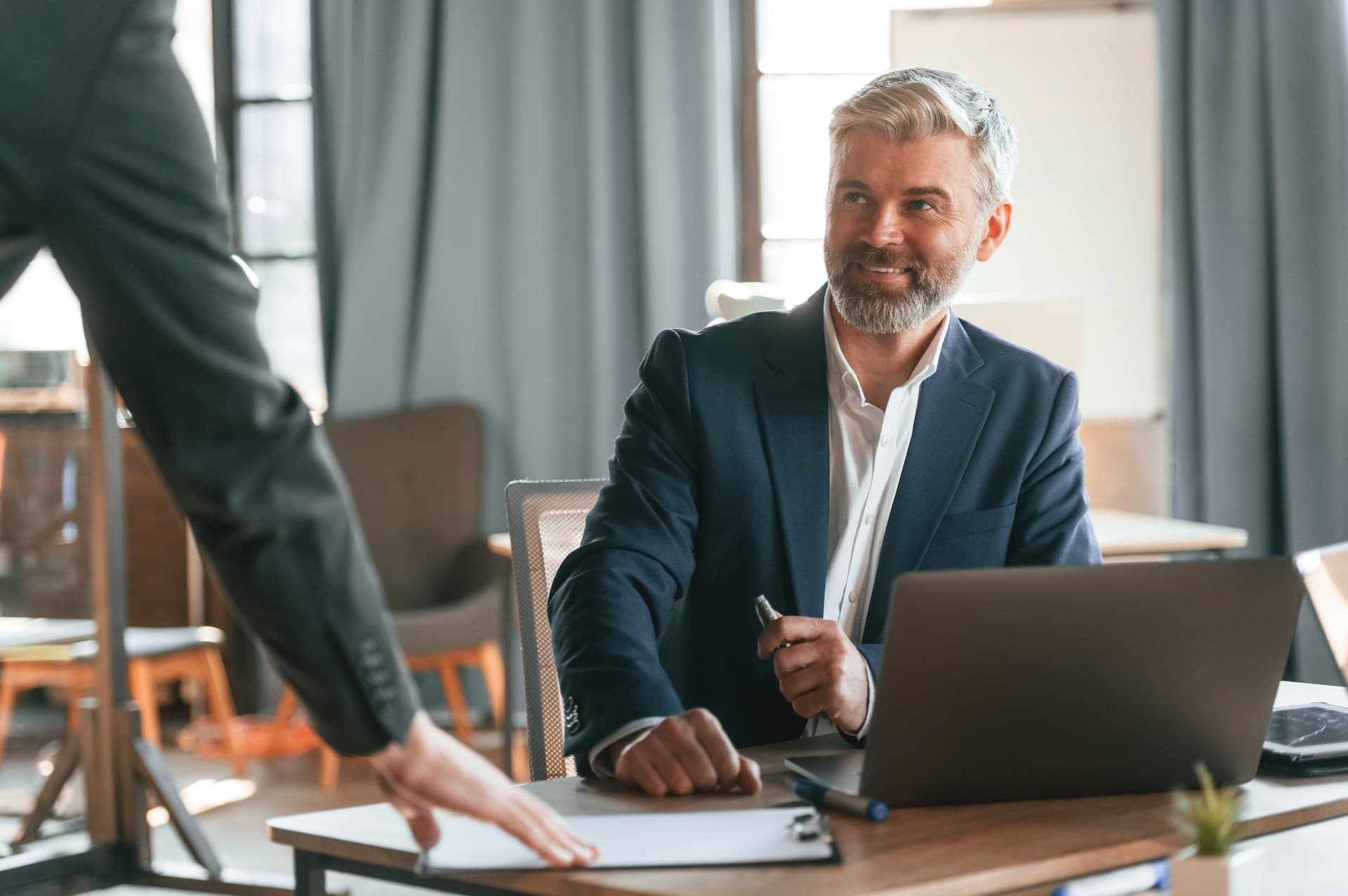 A smiling business man looking over at a colleague