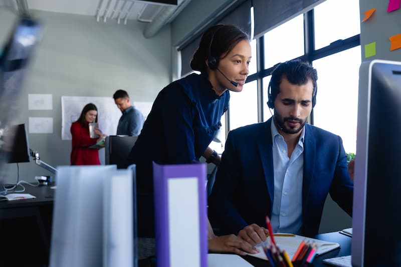 Two office workers looking at computer in a corporate offce