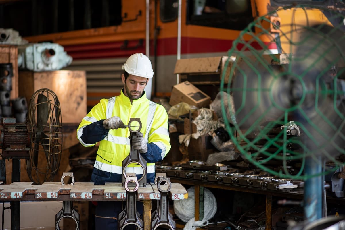 A man measuring parts in a workshop