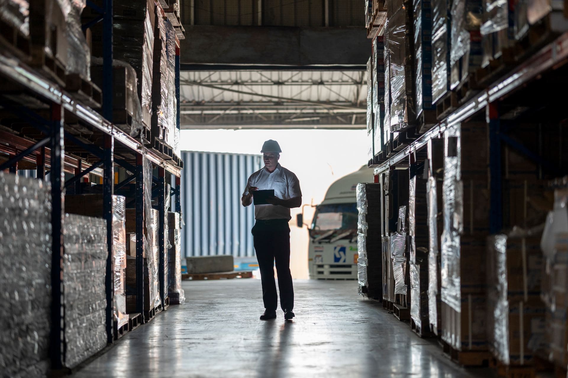 Warehouse manager checking inventory on tablet