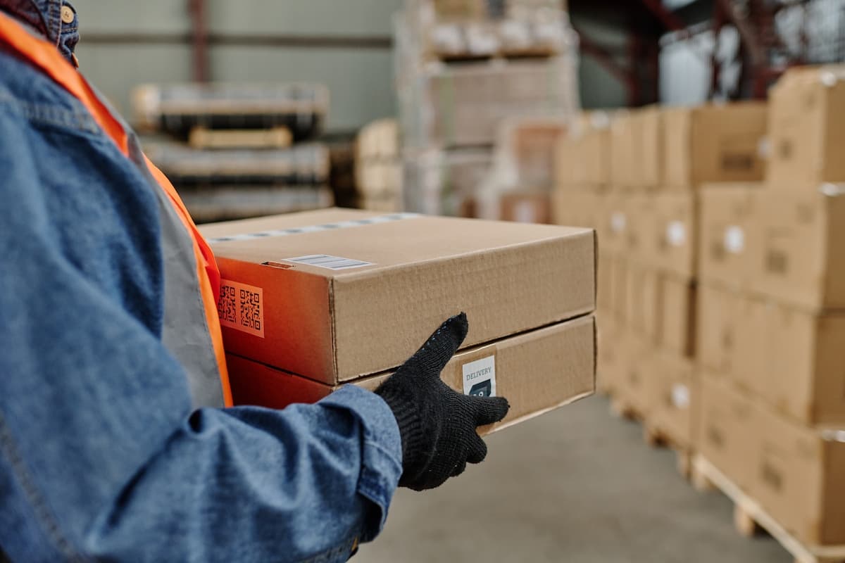 Close up of warehouse worker carrying packages