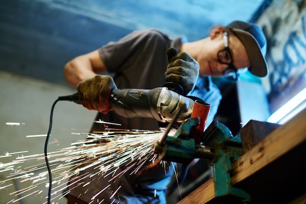 A young man cutting metal